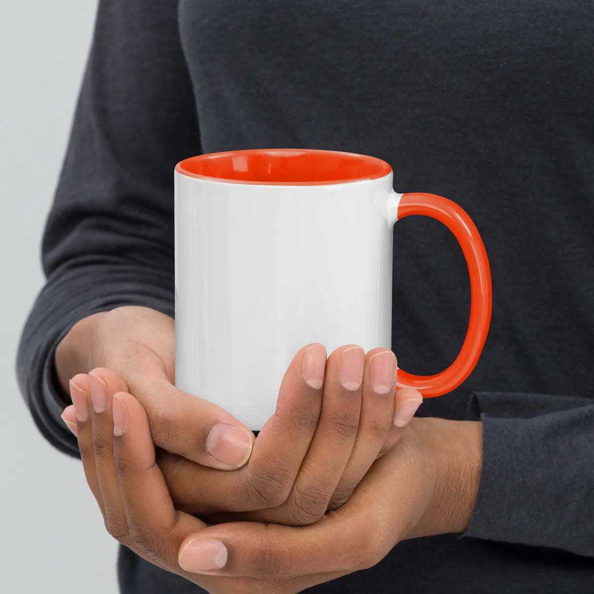 White and orange EL SOL Mug, right side held in hand